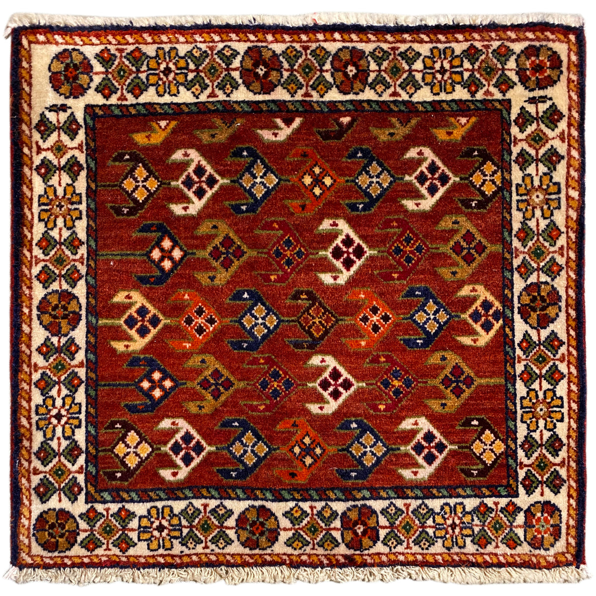 Quadratischer Teppich mit rotem Hintergrund, weiß-bunter Bordüre und Fransen