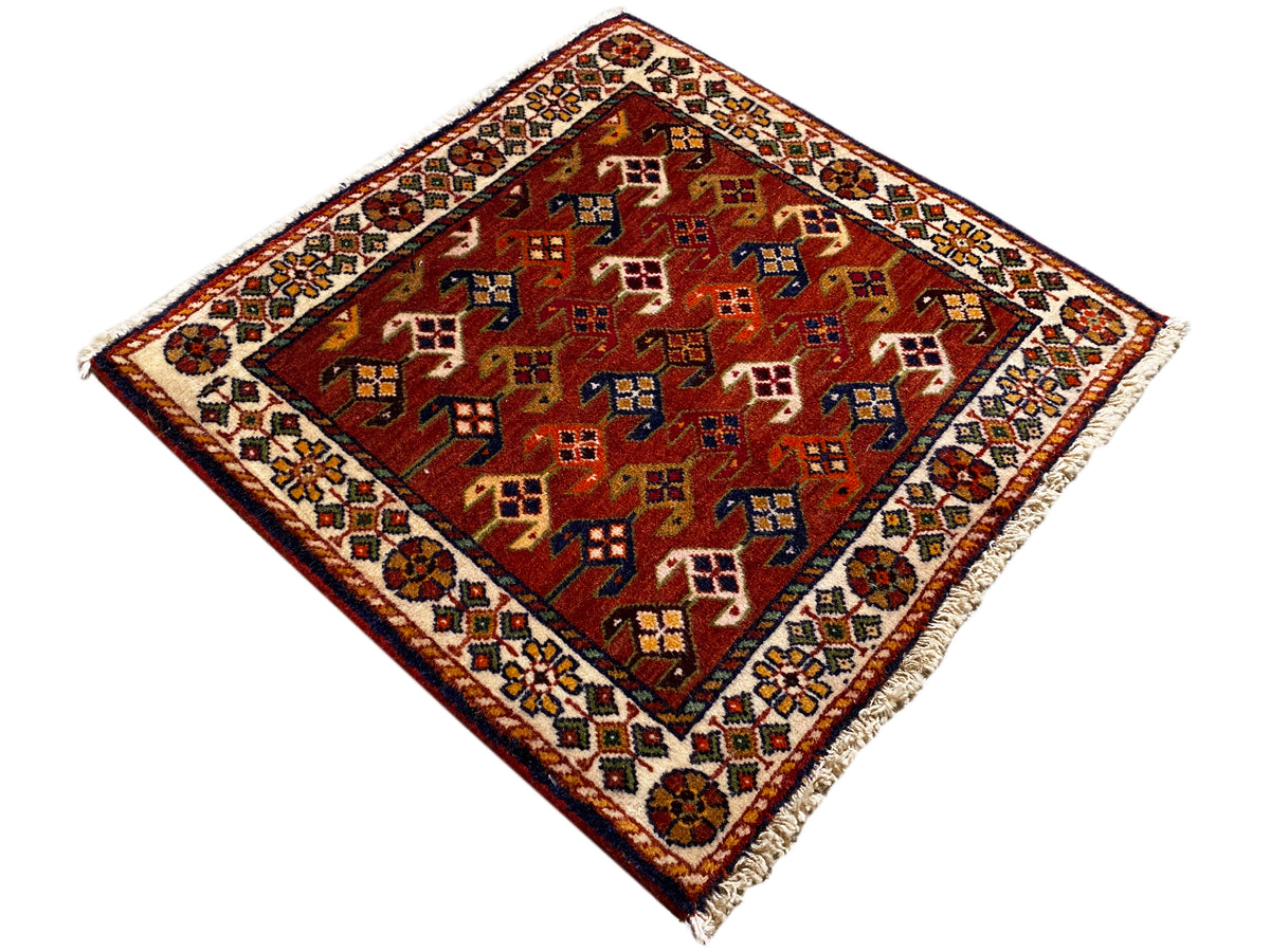 Teppich 61x61 cm mit rotem Grund und bunten geometrischen Mustern, umlaufende Bordüre