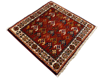 Teppich 61x61 cm mit rotem Grund und bunten geometrischen Mustern, umlaufende Bordüre