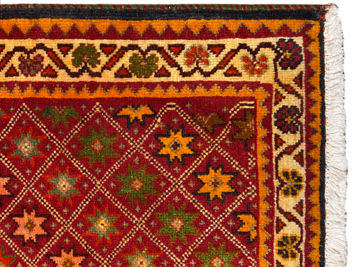 Poshti-Teppich Detailansicht: bunte Ornamentbordüre und dichtes Muster im Innenfeld.