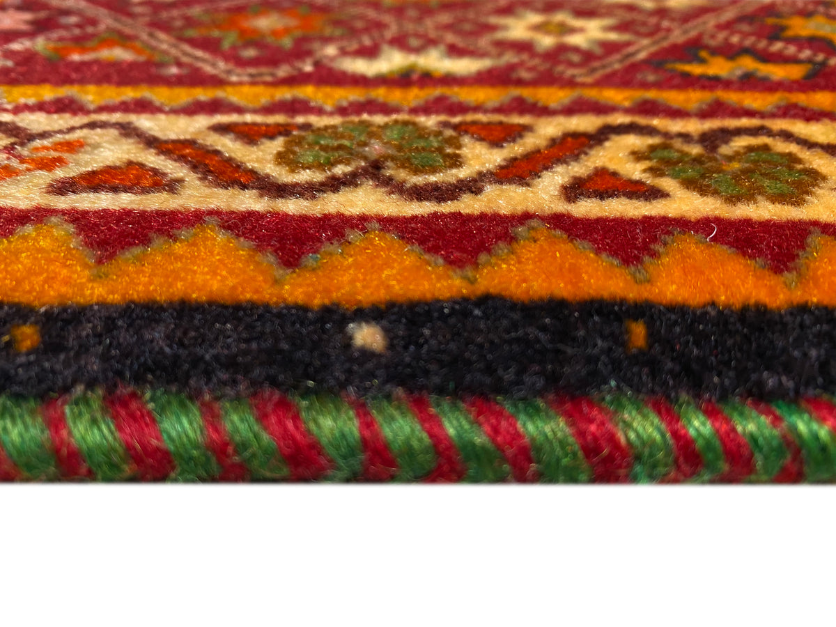 Poshti-Teppich Detail am Rand: farbige Fransen und kurzer Flor auf weißem Untergrund.