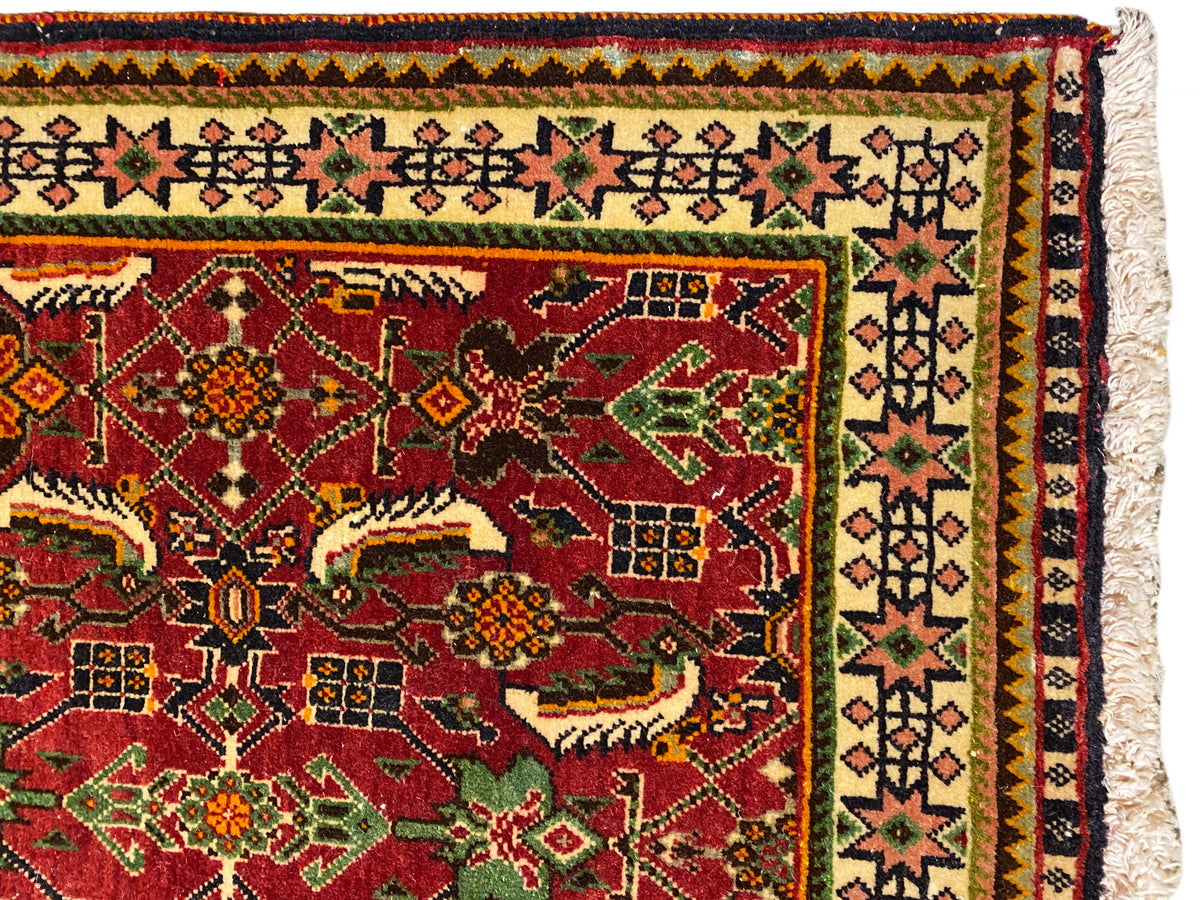 Poshti-Teppich 63x61 cm Detailansicht: rotes Ornamentfeld mit grünen und gelben Motiven.