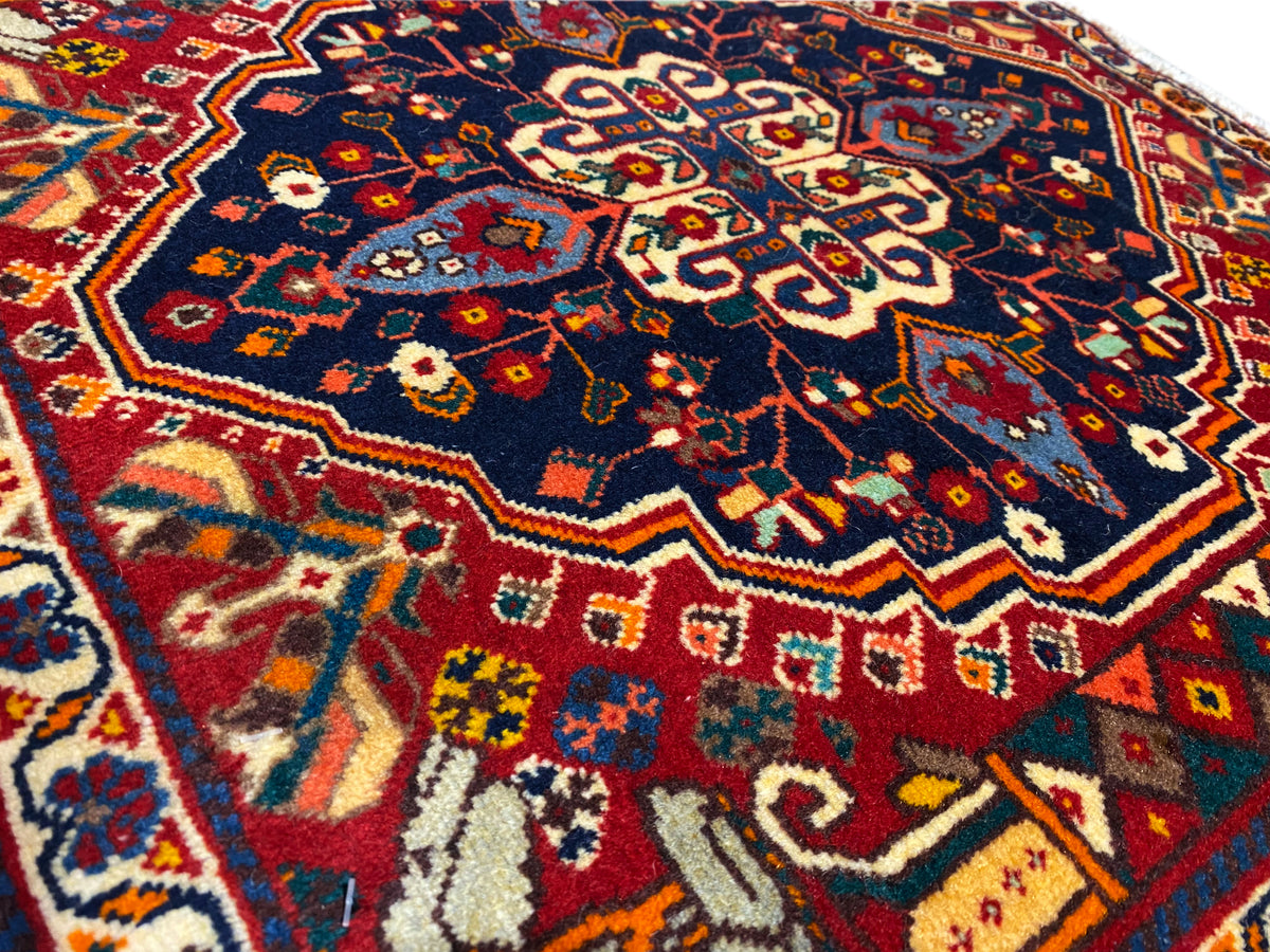Nahaufnahme Teppich: blaues Muster mit roten und gelben Ornamenten, gewebte Struktur