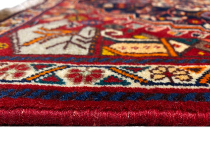 Teppich-Detail am Saum: rot-blaue Bordüre, mehrfarbige Muster und kurze Fransen