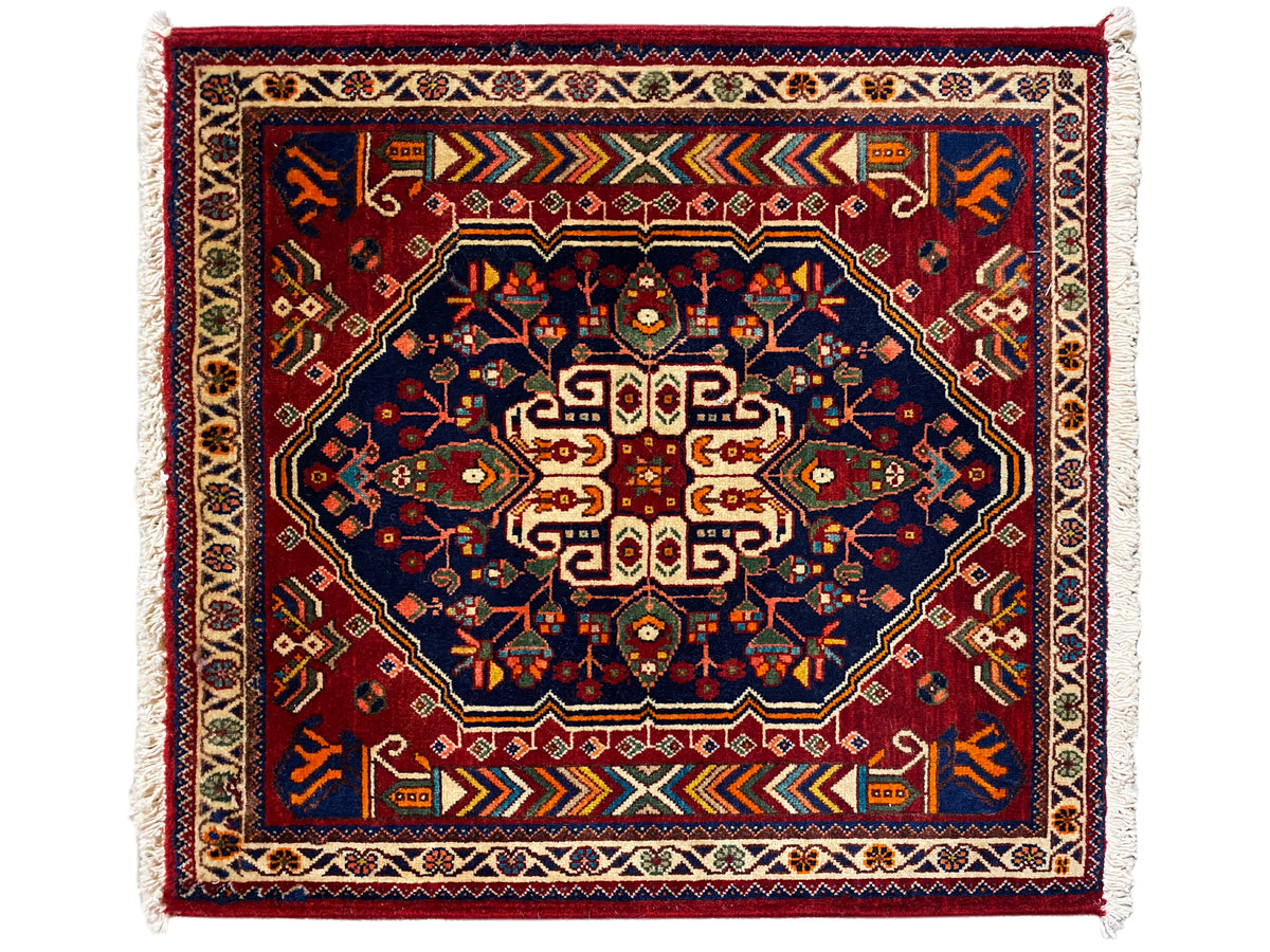 Teppich 63x60 cm in dunkelblau mit rotem Muster, Rahmenstreifen und Fransen