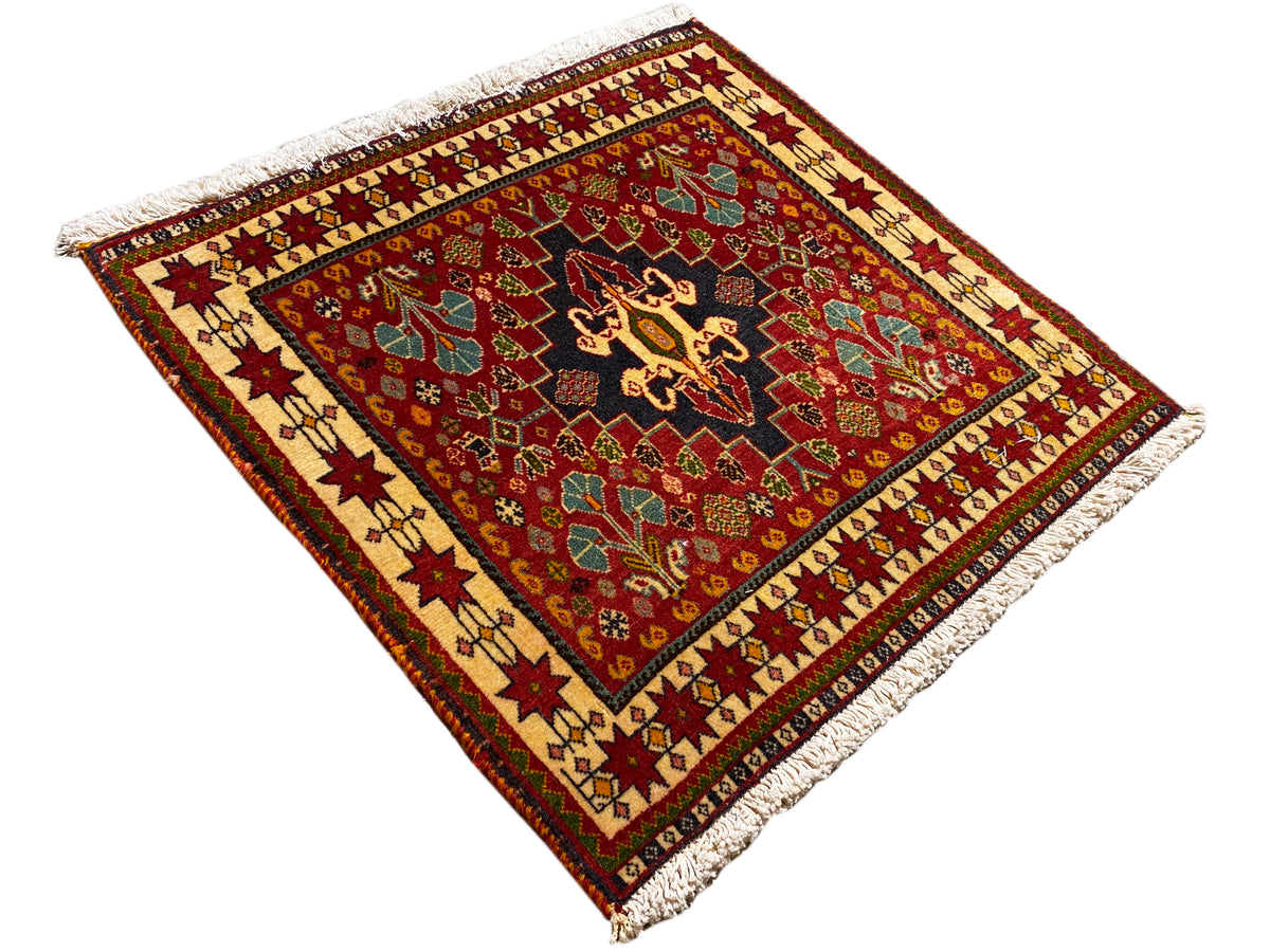 Teppich 60x58 cm, diagonale Ansicht: roter Grund, schwarzes Medaillon, Eckfransen