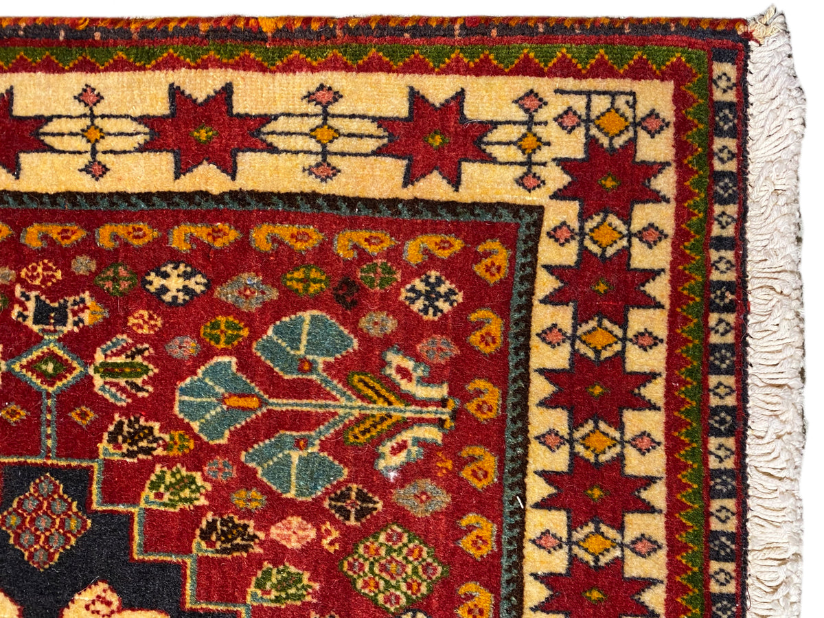 Teppich im Detail: mehrfarbige Bordüre und Ornamentmotive, seitlicher Fransenrand