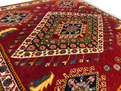 Poshti-Teppich Detail: rotes Muster mit farbigem Medaillon und umlaufender Bordüre