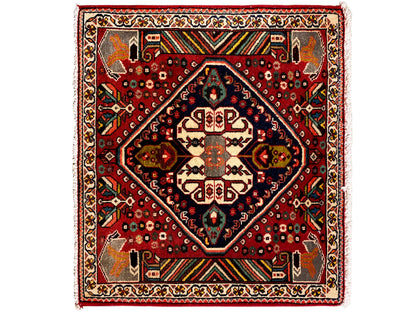 Orientalischer Teppich mit rotem Grund, dunkelblauem Medaillon und geometrischen Ornamenten