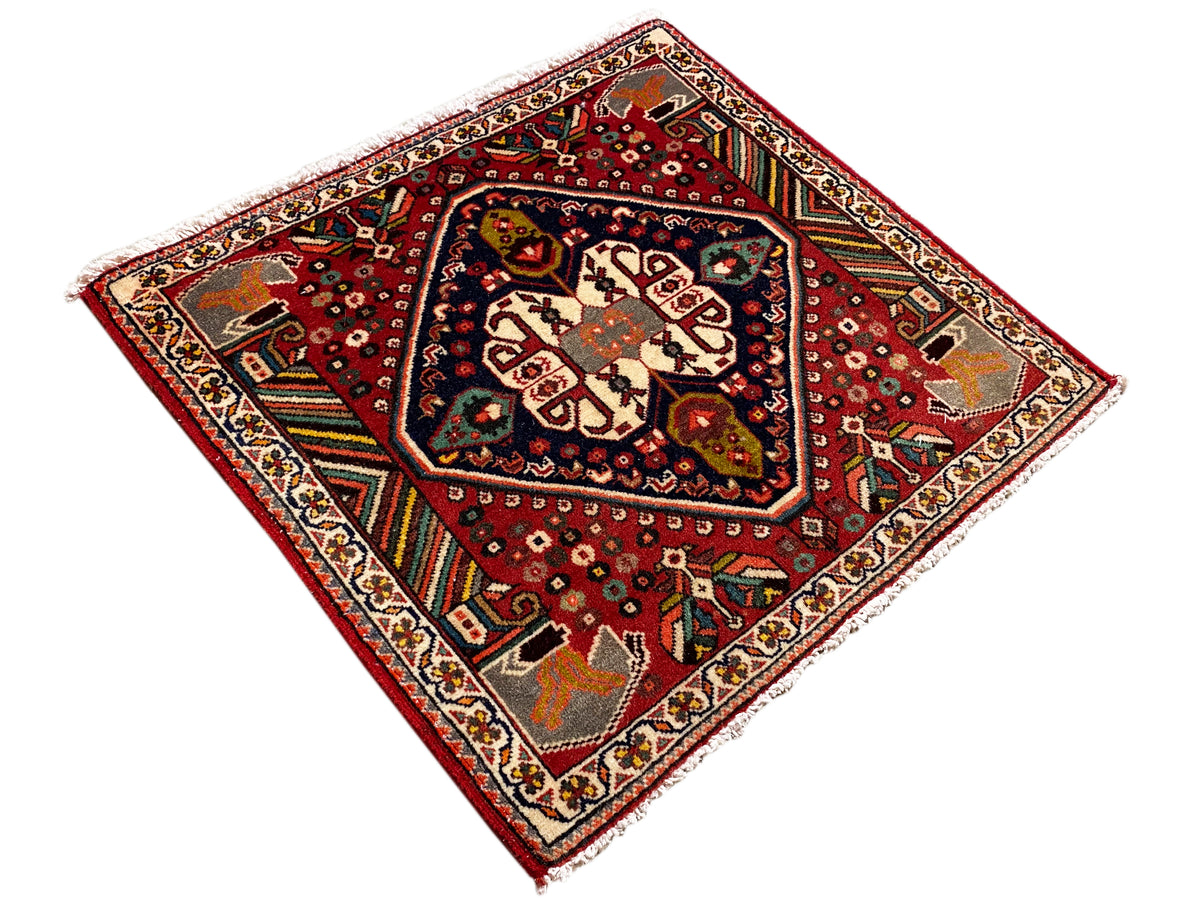 Orientalischer Teppich im Quadratformat mit rotem Grund und blau umrandetem Mittelfeld