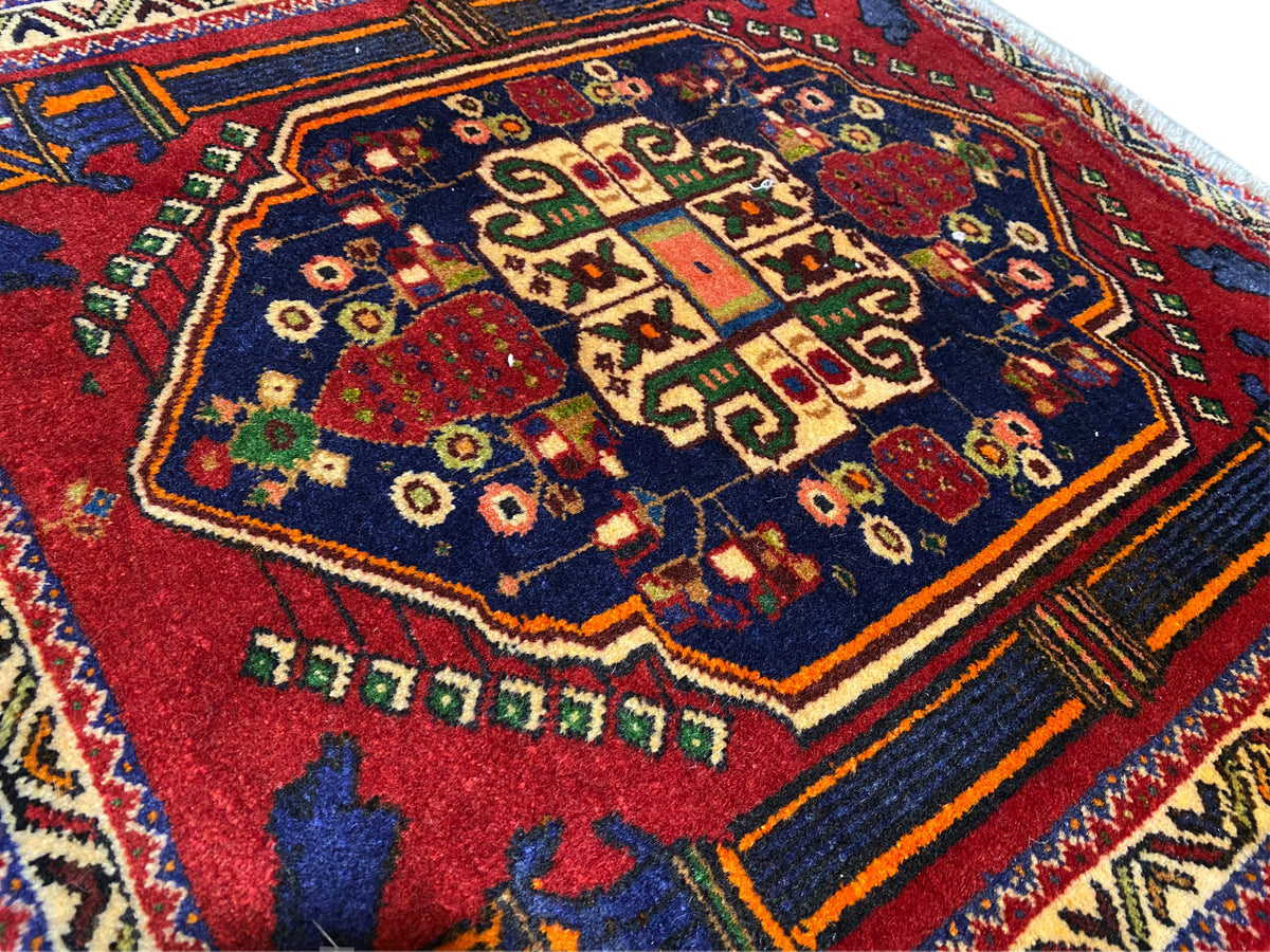Poshti-Teppich 66x62 cm Detail: rotes Zentralmuster, blaues Feld und bunte Zierlinien.
