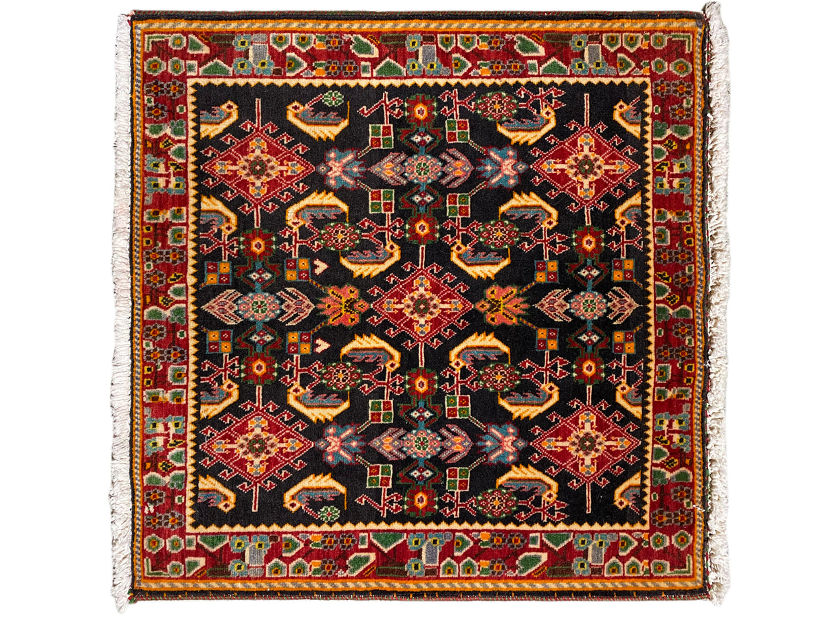 Teppich mit quadratischem Ornamentmuster, schwarz als Basis, Rot-, Gelb- und Grüntöne