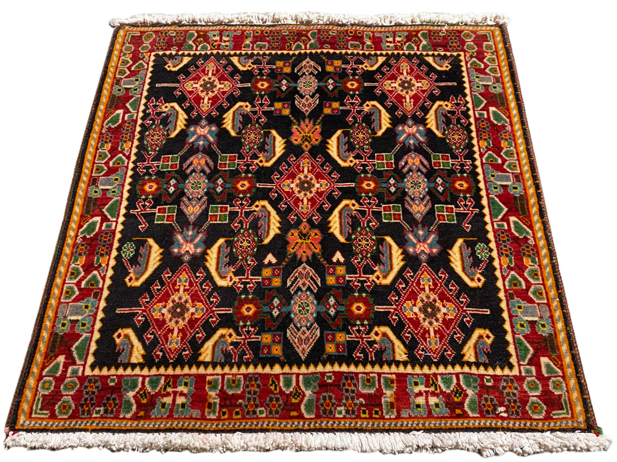 Teppich mit symmetrischem Poshti-Muster, schwarze Grundfläche, Rot-, Gold- und Grüntöne
