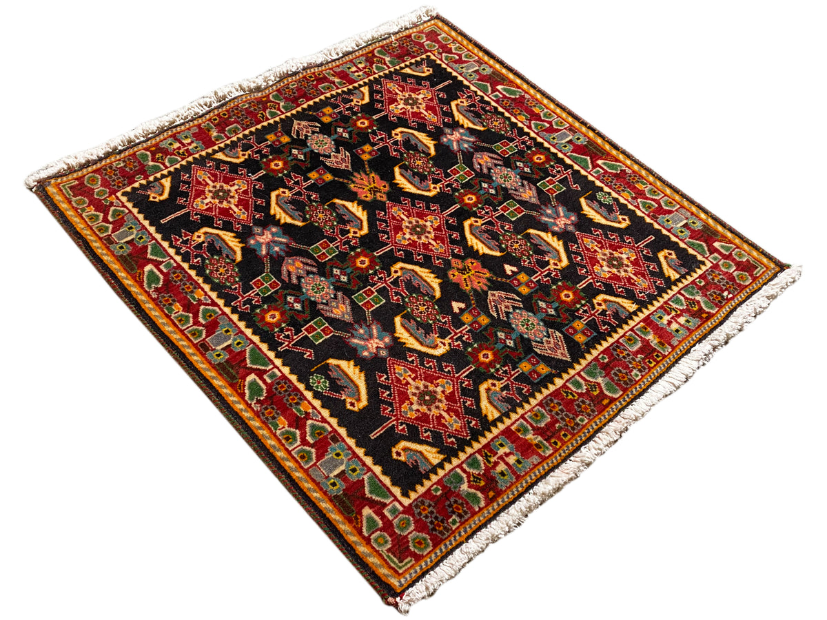 Teppich mit Rautenoptik, schwarz mit Rot-, Orange-, Gelb- und Grüntönen, gesäumt