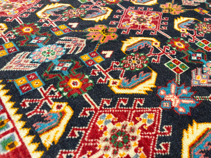 Teppichoberfläche mit buntem geometrischem Muster, schwarz, Rot, Grün und Gelb