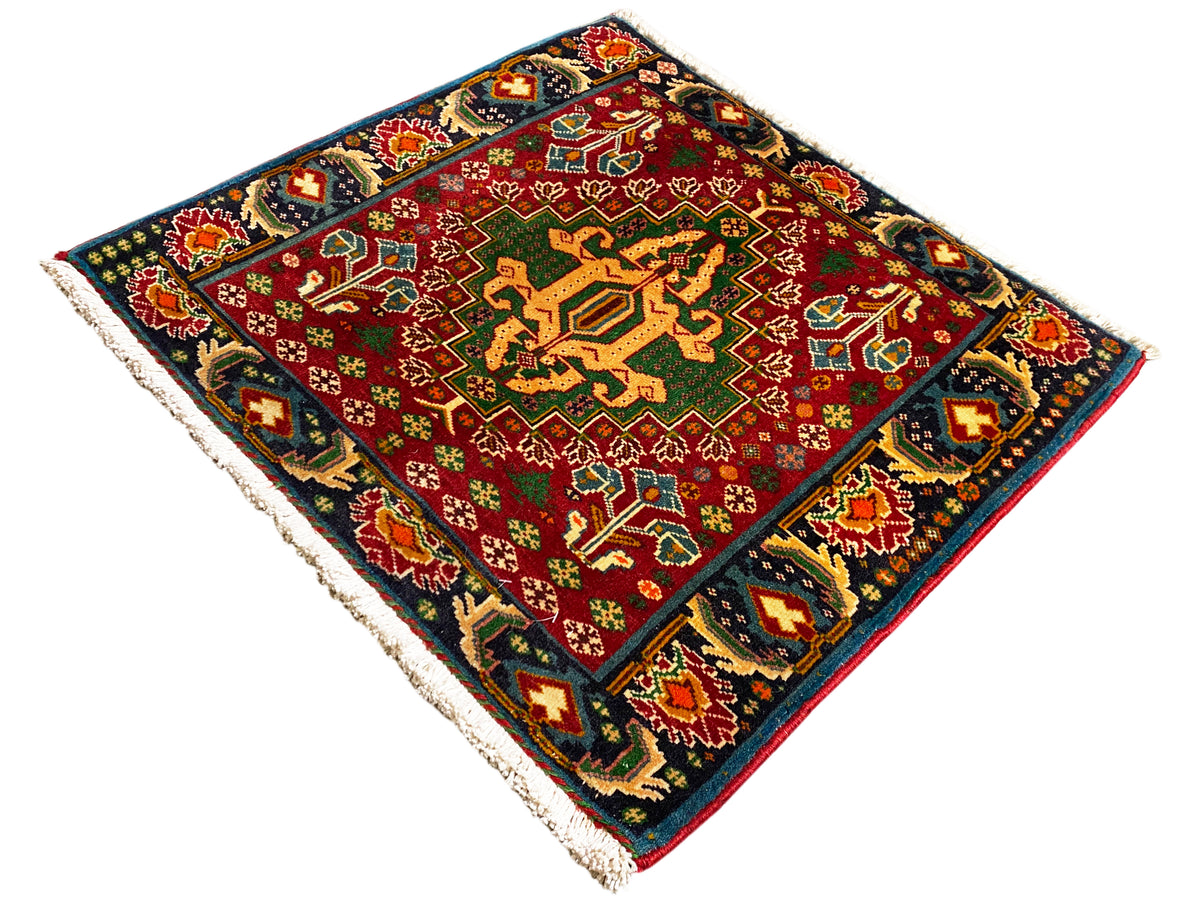 Rechteckiger Teppich (67x66 cm) mit rotem Zentrum, dunklem Rand und mehrfarbigen Ornamenten, Fransen