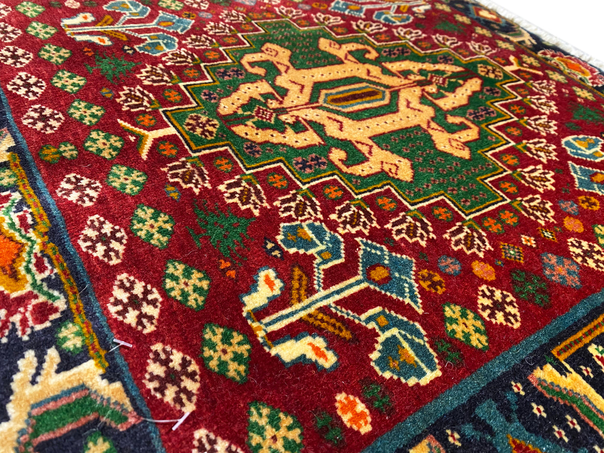 Teppich-Vorderseiten-Detail mit rotem Feld, sternförmigen Mustern und türkisen Linien, strukturierter Flor