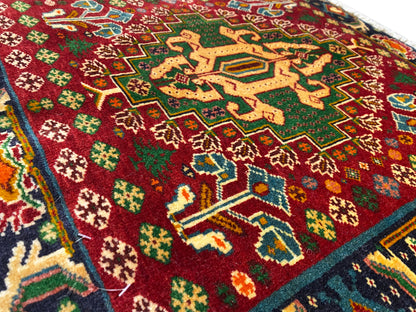 Teppich-Vorderseiten-Detail mit rotem Feld, sternförmigen Mustern und türkisen Linien, strukturierter Flor