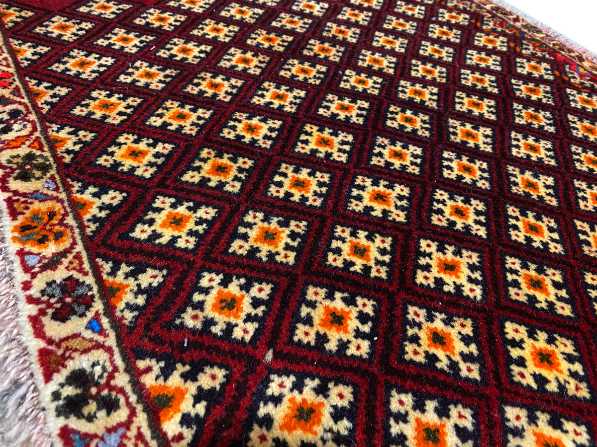 Poshti-Teppich 61x59 cm: Nahansicht des Musters mit bunten Rauten auf dunkelrotem Grund