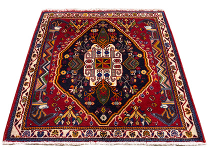 Poshti-Teppich (67×67 cm) im Schrägbild: Bordüre, rotes Zentrum, dunkles Blau
