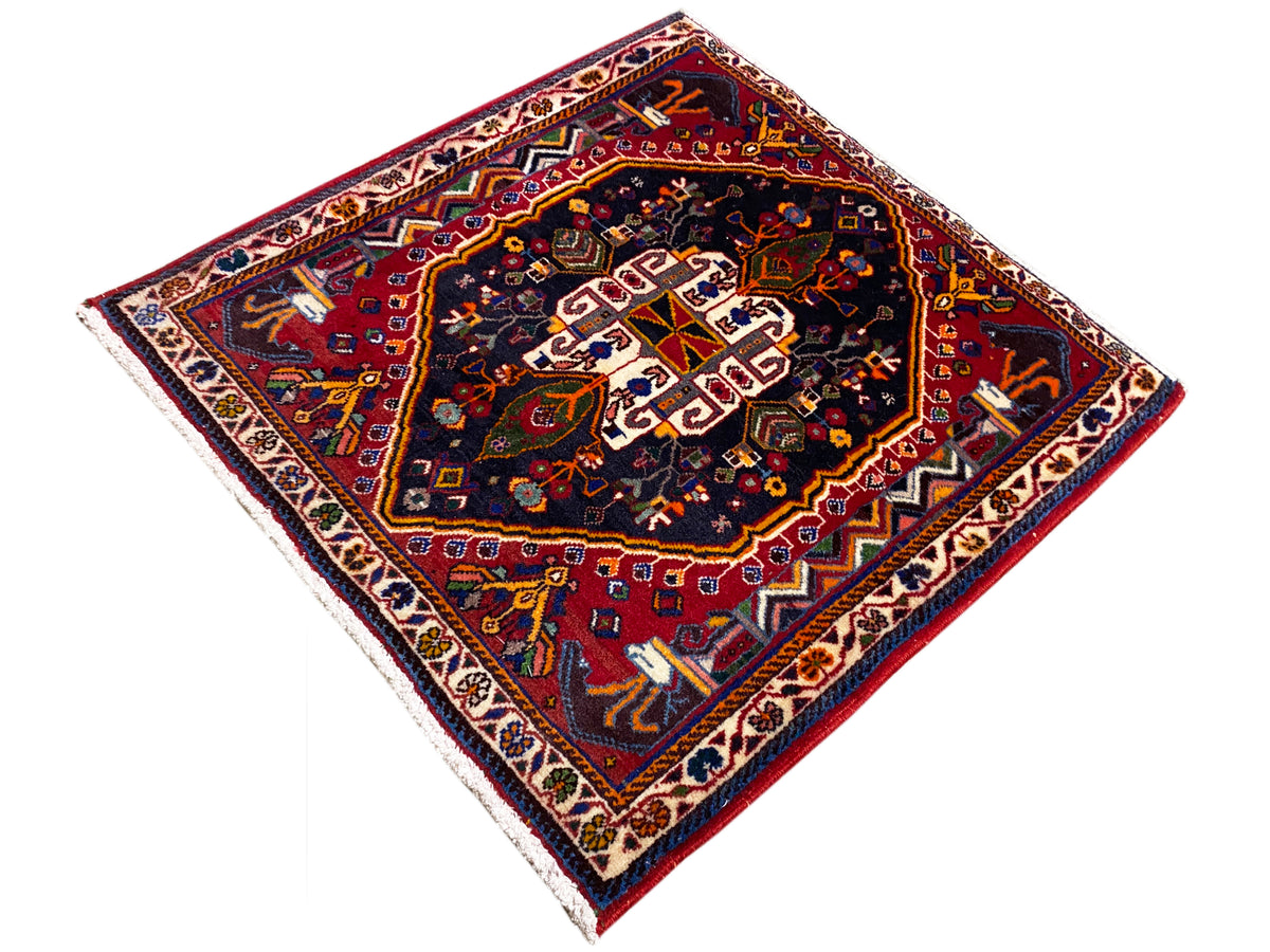 Teppich 70x67 cm: dunkles Ornamentmuster im Zentrum, rot-blaue Farbpalette, Randbordüre