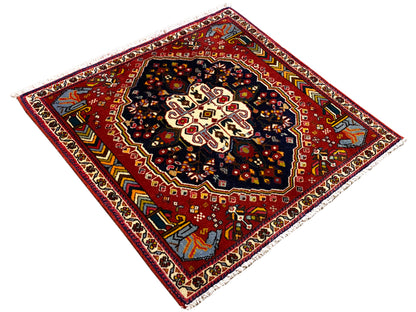Poshti Teppich 65x61 cm, diagonale Ansicht: roter Hintergrund mit dunkelblauem Zentrum