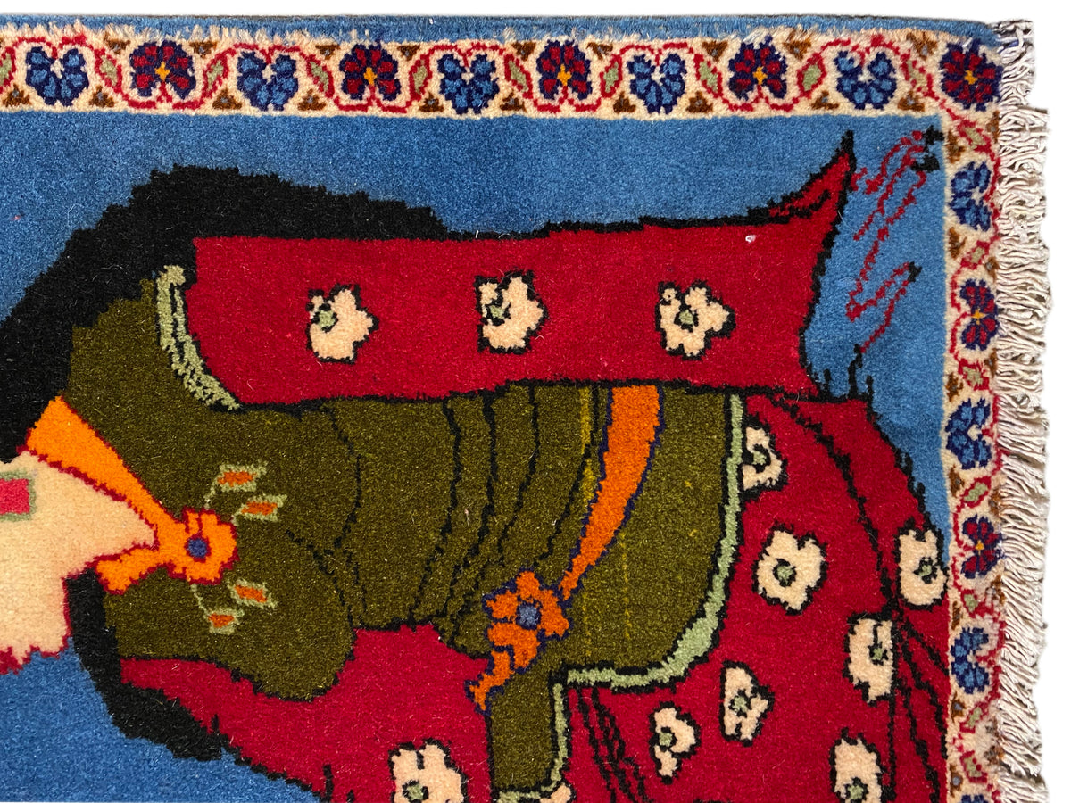 Poshti Teppich 65x63 cm Nahansicht: Figur mit grünem Gewand, rotes Feld und Fransenrand